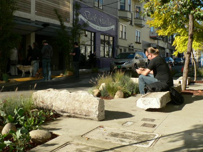 man seated on bench in tree lined alley